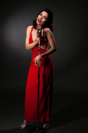 Brunette chanteuse in a vintage red dressの写真素材
