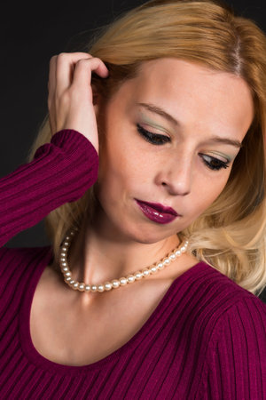 Pretty blonde woman in a purple sweaterの写真素材