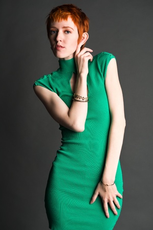 Pretty slender redhead in a green knit dressの写真素材