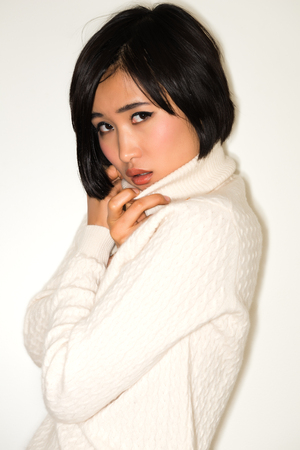 Beautiful young Japanese woman in a white knit sweaterの写真素材