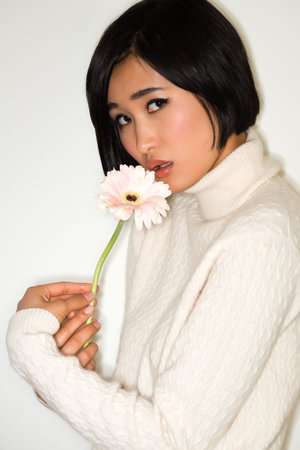 Beautiful young Japanese woman in a white knit sweaterの写真素材