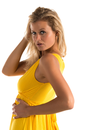 Beautiful tall blonde woman in a short yellow dressの写真素材
