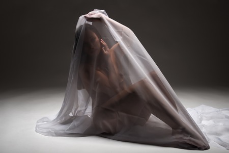 Beautiful nude tanned Latina wrapped in white fabricの写真素材