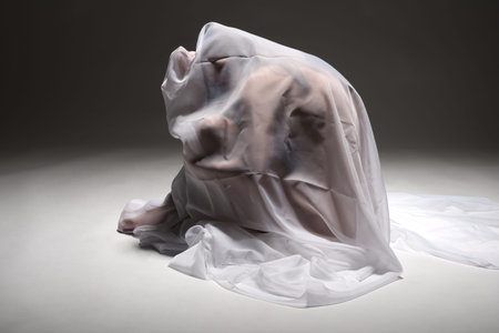 Beautiful nude tanned Latina wrapped in white fabricの写真素材