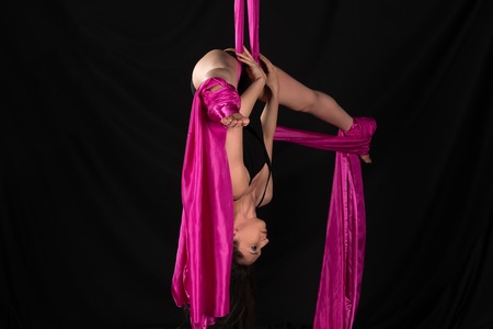 Petite young brunette suspended from a purple fabricの写真素材