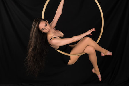 Petite young brunette on an aerial ring