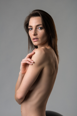 Beautiful slender Italian woman nude on grayの写真素材