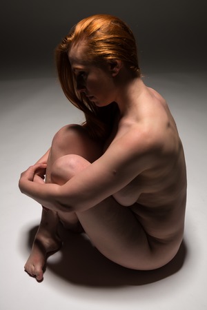 Curvy young redhead nude on whiteの写真素材
