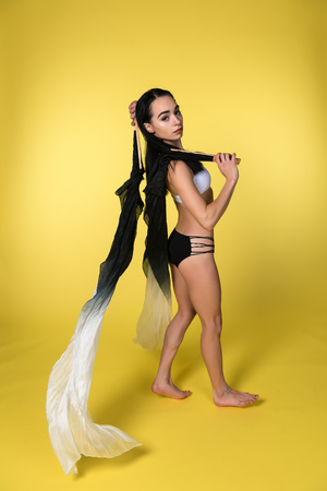 Petite young brunette working with rhythmic gymnastics ribbonsの写真素材