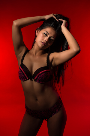 Beautiful petite Filipino woman in red and black lingerieの写真素材