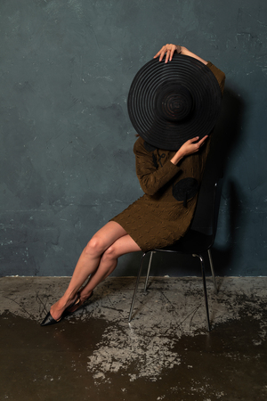 Tall slender Ukrainian brunette in a brown dress and black hatの写真素材