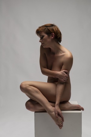 Mature English redhead nude on a white cubeの写真素材
