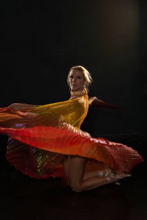Beautiful slender blonde woman waving bright translucent wingsの写真素材