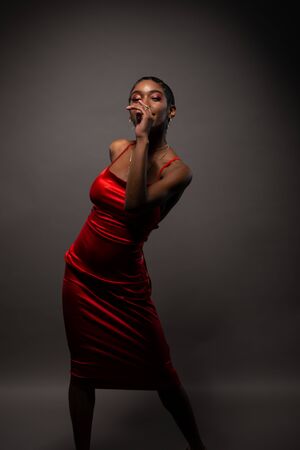 Slender young African American woman in a tight red dressの写真素材