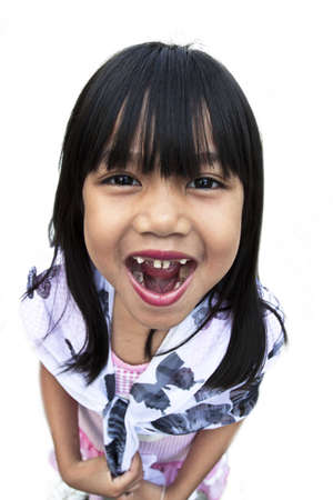 A young pretty girl five years old loosing her teeth and showing her mouth with the missing teeth, for white background.の写真素材