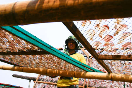 Thai worker drying squid on the sun in Thailandのeditorial素材