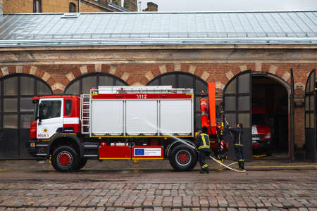 RIGA, LATVIA - MARCH 16, 2019: Fire truck is being cleaned - Driver washes firefighter truck at a...
