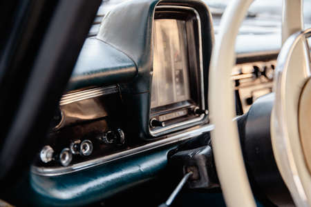Retro styled image of an old car radio and dashboard inside a classic car