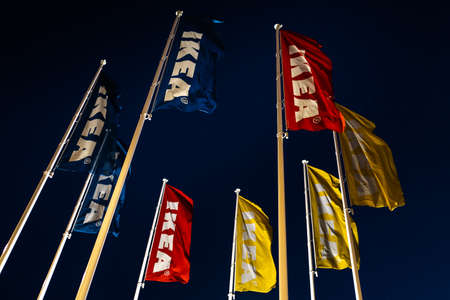 RIGA, LATVIA - APRIL 3, 2019: IKEA flags during dark evening and wind - Blue sky in the backgroundのeditorial素材