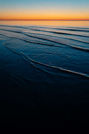 Vivid amazing sunset in Baltic States - Dusk in the sea with horizon illuminates by the sunの写真素材