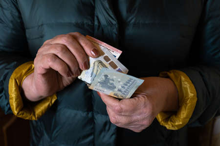 Older senior woman holds EURO banknotes - Eastern European salary pensionの写真素材
