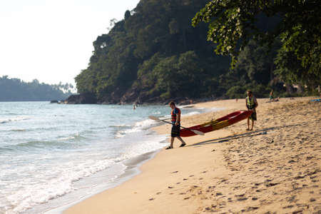 KO CHANG, THAILAND - APRIL 9, 2018: People men sweaming on a kayak boat - Beautiful tropical paradise beachのeditorial素材