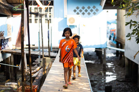 KO CHANG, THAILAND - APRIL 10, 2018: Authentic traditional fishermens village on the island - People and children in their natural habitat with bikes and fish netsのeditorial素材