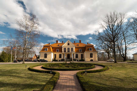 LIEPUPE, LATVIA - APRIL 13, 2019: Liepupes Muiza manor in beautiful sunny Spring weather with blue sky and cloudsのeditorial素材