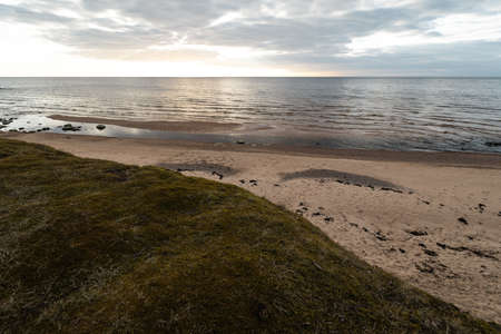 Moss sand and cloudy sky on the beach on the Baltic Sea - Veczemju Klintis, Latvia - April 13, 2019の写真素材