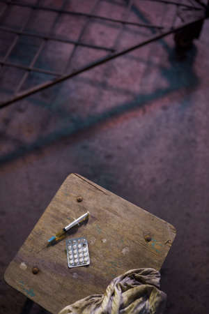 Grabbing filled syringe on a table - Anxiety, depression and danger feeling - Pack of narcotic pillsの写真素材