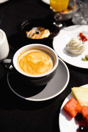 Sunny cup of coffee in an outdoor garden table in direct sunlight very brightの写真素材