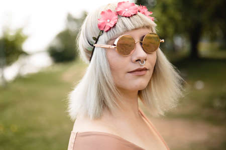 Young blonde hippie woman with heart glasses and flower band