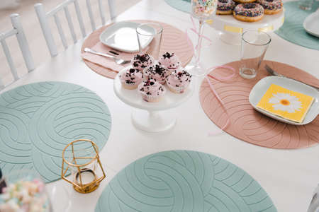 Food served on table in a white hall during a children Birthday party decoration in Eastern European Baltic Riga Latvia - Mild Biege, creme, pink colors - Canape, snacks and light drinksの写真素材