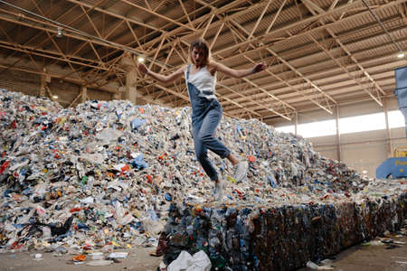 Nature pollution activist at a huge trash dump - Young blonde woman - Looking at all the human waste and plastic in our world in Eastern Europe Latvia Rigaの写真素材