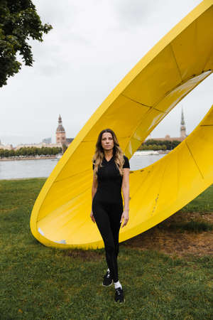 Fit slim woman warming up and exercising near Riga river Daugava at sunset - Shot of urban city...