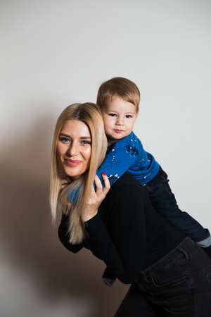 Blonde long hair hot glamour mother playing with her baby boy child at home spending quality family values timeの写真素材