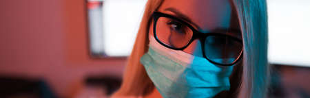 Blonde woman in surgical mask and glasses