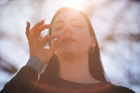 Addictive young woman smokes cigarette in parkの写真素材