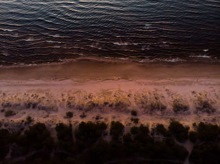 Rich sunset colors of Baltic beach and waves aerial top viewの写真素材
