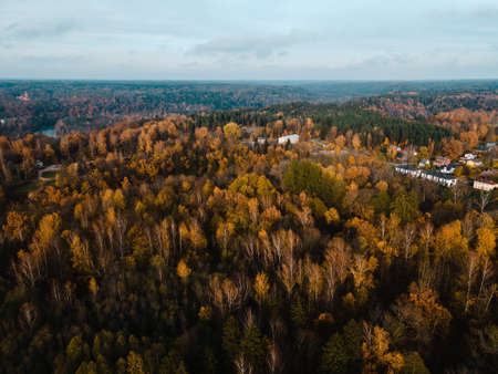 Aerial view: Small lonely church among autumn trees in countryside in Europe