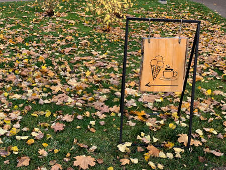 Outside view of wooden sign at cafe inviting for cup of coffee or ice creamの写真素材