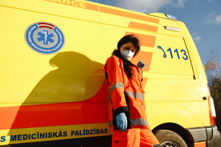 Young female paramedic posing near ambulance vehicleの写真素材