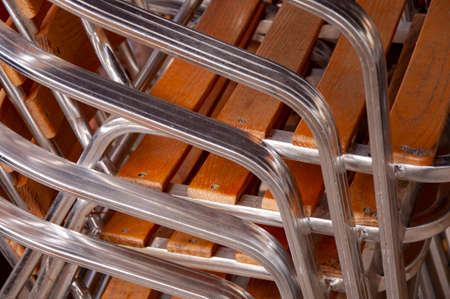 Close Up of metal wooden chairs stacked in a pile.の写真素材