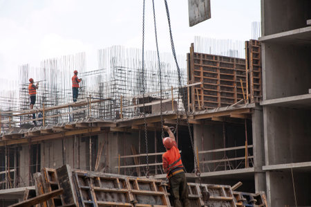 The builders make reinforcement strapping and attach the load to the tower crane hookのeditorial素材