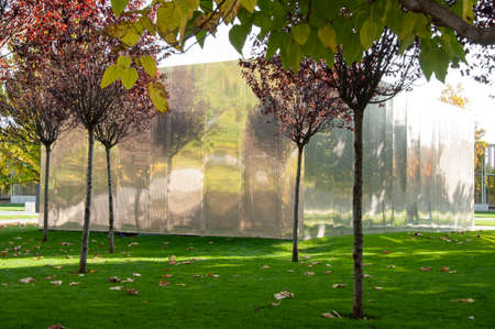 the metal facade of the building, which stands in a park among treesの写真素材