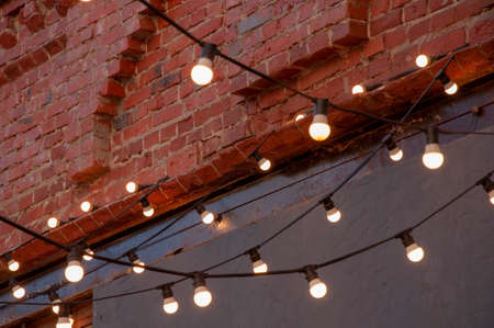 Old red brick wall with bulb lights lamp