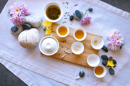 Chinese white tea cups with black tea on a bamboo board, beautiful white porcelain gaiwan zhong,...