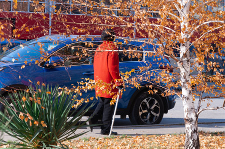 senior lady walking at autumn cold weather in red coatの写真素材