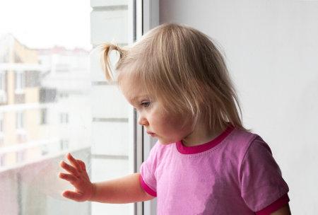 child looks out the window, selective focusの写真素材