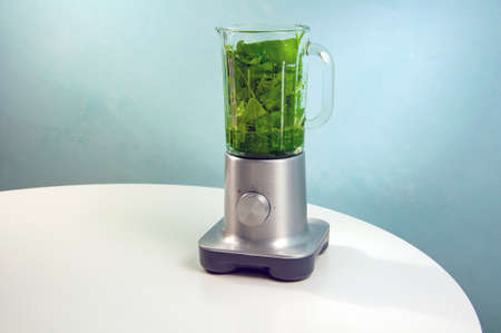 A blender with a glass jug stands on a white table.の写真素材